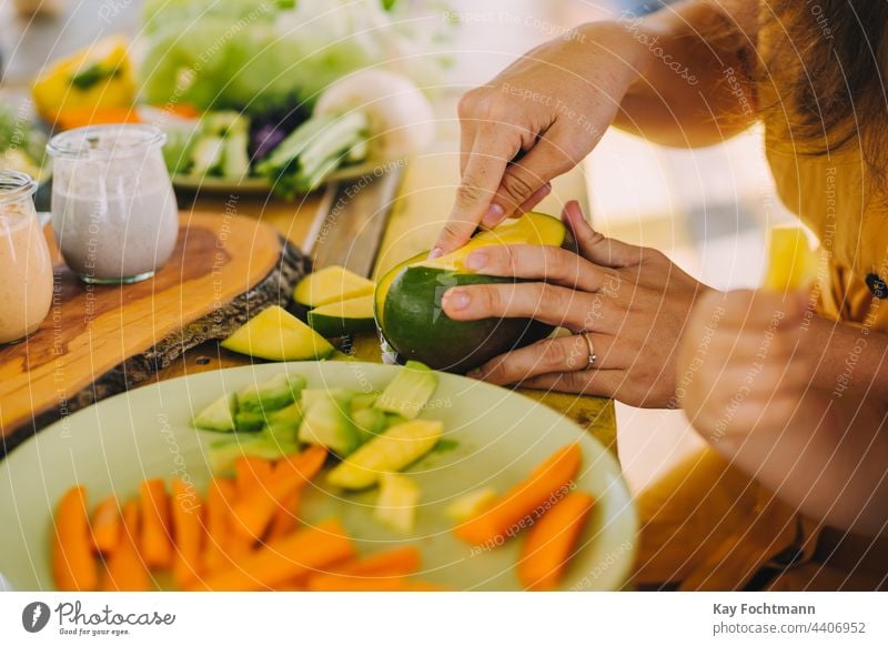 Foto einer Frau, die eine Mango zubereitet Amuse-Gueule Möhre Nahaufnahme geschnitten Schneiden lecker Diät Abendessen Speise exotisch Lebensmittel