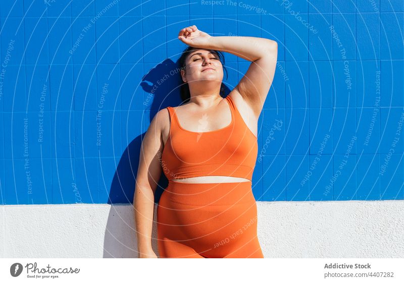 Plus size ethnische Sportlerin mit Hand auf dem Kopf Athlet Hand auf der Taille Gesunder Lebensstil Vitalität Wellness selbstsicher mollig Frau Straße Energie