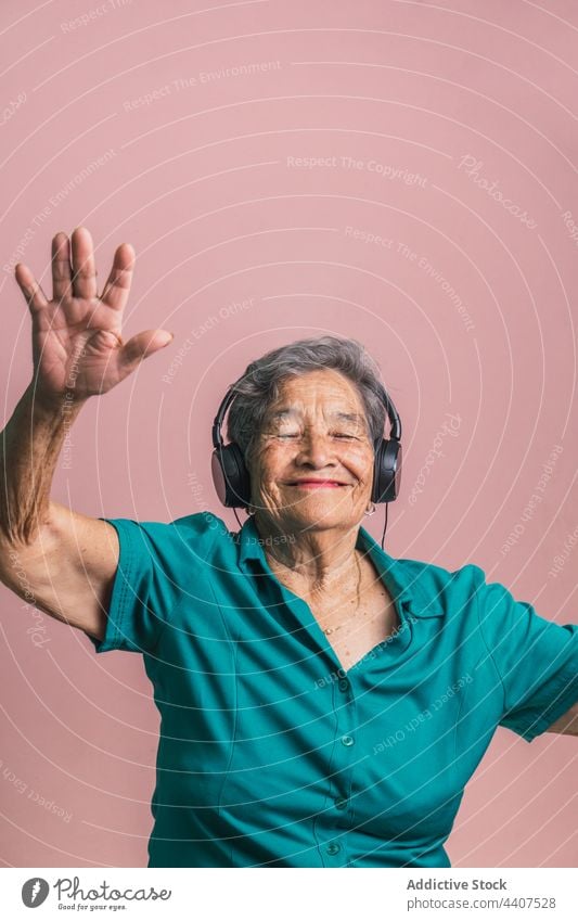 Glückliche ältere Frau, die mit Kopfhörern Musik hört Senior zuhören modern gealtert heiter Spaß haben Tanzen Stil Audio Klang genießen Gerät trendy positiv