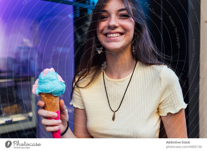 Glückliche Frau mit leckerer Eistüte in der Stadt Speiseeis Zapfen Lächeln Dessert Leckerbissen süß geschmackvoll Porträt Waffel Straße knackig gelato Geschmack