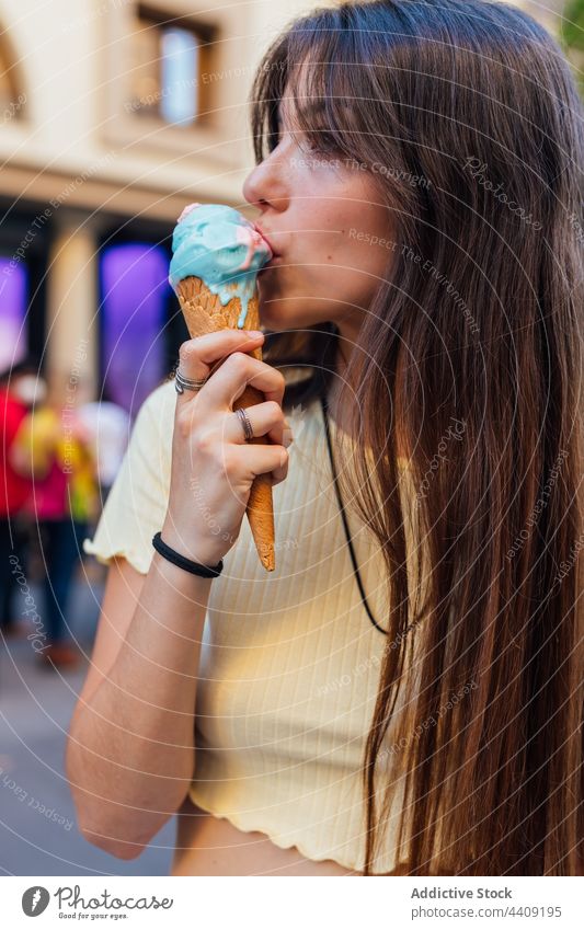 Crop-Frau genießt leckere Eiswaffel auf der Straße lutschen Speiseeis Zapfen Waffel Dessert Leckerbissen süß genießen knackig gelato Geschmack Vergnügen