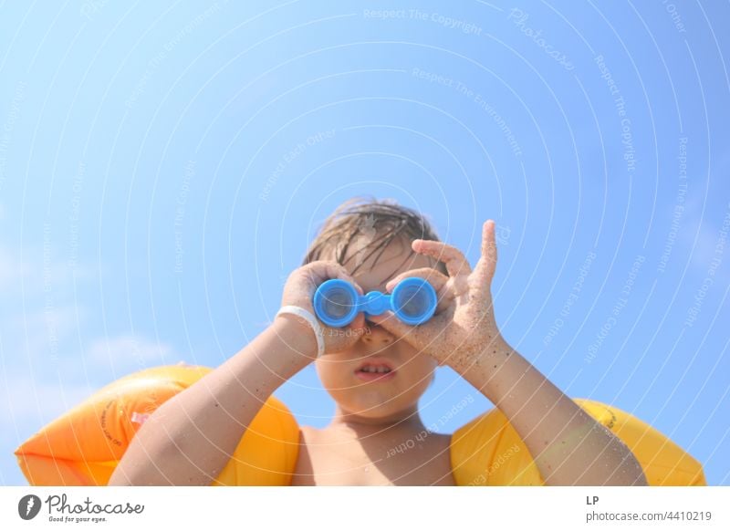 Kind schaut durch ein Spielzeugfernglas im Freien Wegsehen beobachten positiv Ufer Freiheit Urlaub Fernglas Seeküste genießend sorgenfrei Kindheit lässig