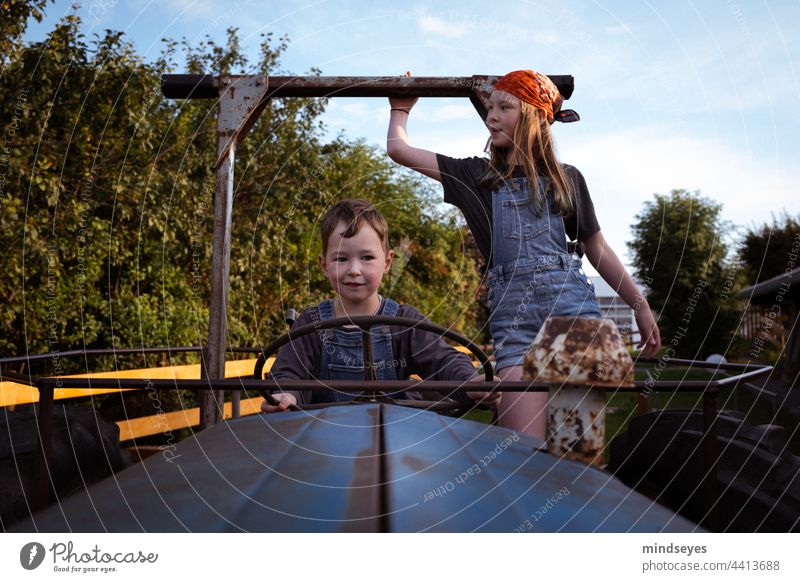 Kinder spielen auf dem Traktor Bauernhof Schlepper Kindheit Spielen fahren Ackerbau Natur Fahrzeug landwirtschaftlich Landwirt Urlaub auf dem Bauernhof