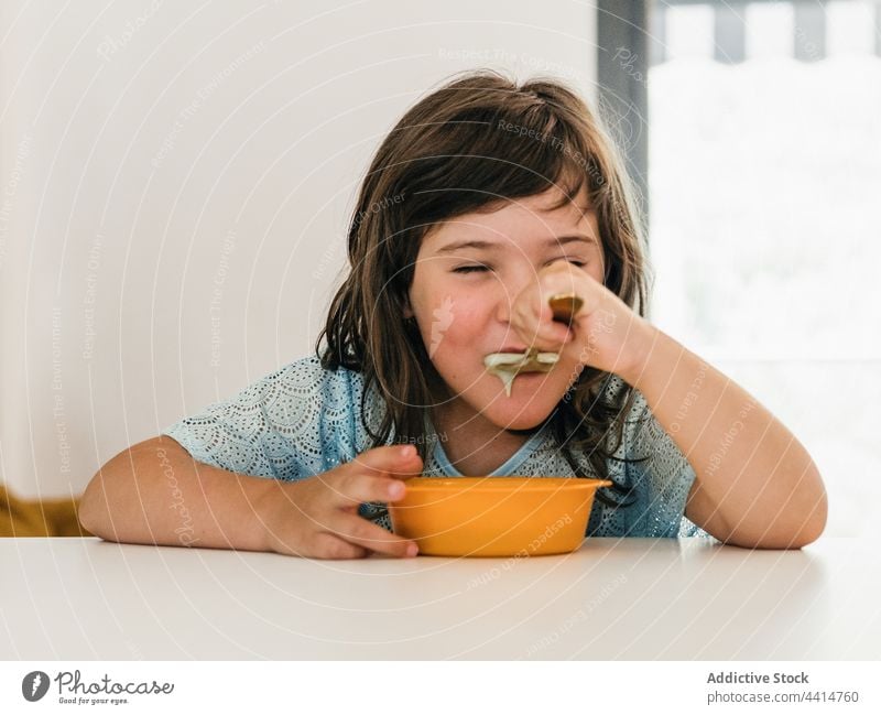 Lustiges Mädchen isst Cremesuppe beim Mittagessen Kind Suppe heimwärts lecker Sahne Püree Schalen & Schüsseln Tisch Lebensmittel Mahlzeit Kindheit Gesundheit