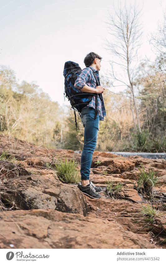 Reisender Mann steht in der Nähe eines kleinen Wasserfalls im Wald Rucksack Wanderer Trekking Wälder reisen Abenteuer männlich Natur erkunden Backpacker Umwelt