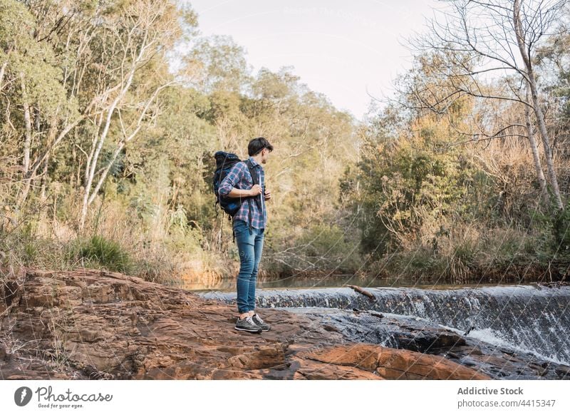 Reisender Mann steht in der Nähe eines kleinen Wasserfalls im Wald Rucksack Wanderer Trekking Wälder reisen Abenteuer männlich Natur erkunden Backpacker Umwelt