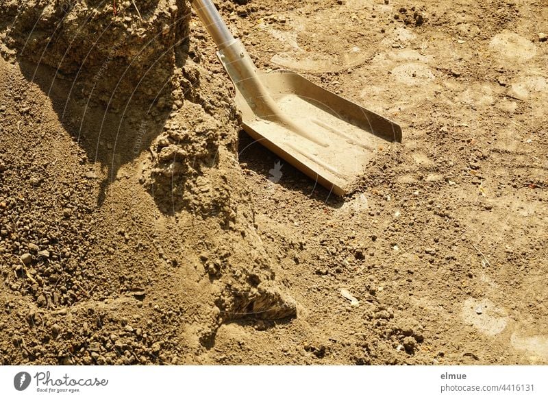 Schaufelblatt mit Metallstiel und ein Berg Kies / Werkzeug / Bauarbeiten Stiel Schaufelstiel Fußabdruck schaufeln Handarbeit bauen Handwerk