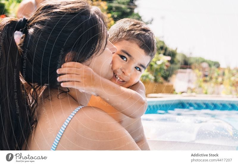 Junge Frau mit Sohn im Schwimmbad Lächeln Sommer Pool Wasser Garten schwimmen Zusammensein Urlaub Mutter Baum Natur Eltern Mutterschaft Beckenrand Kind Kindheit