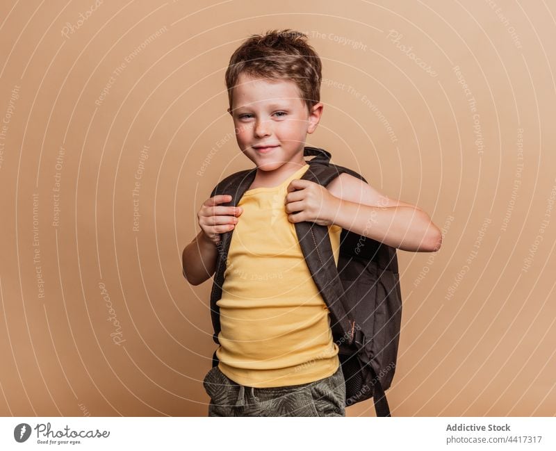 Lächelnde Schülerin mit Rucksack im Atelier Pupille Kind Junge cool Schuljunge Schulkind heiter Glück positiv Kindheit froh Optimist Stil Zahnfarbenes Lächeln