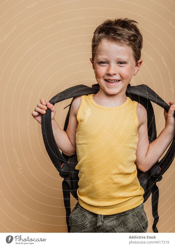 Lächelnde Schülerin mit Rucksack im Atelier Pupille Kind Junge cool Schuljunge Schulkind heiter Glück positiv Kindheit froh Optimist Stil Zahnfarbenes Lächeln