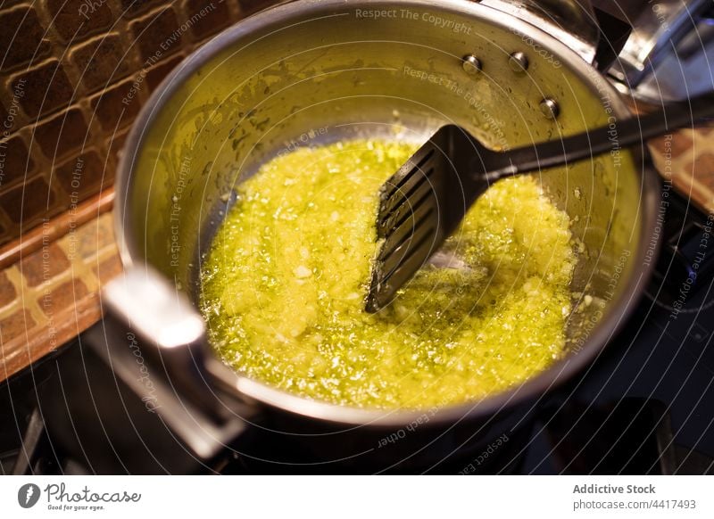 Crop kochen braten gehackte Zwiebel in der Pfanne Koch Knoblauch Küche kulinarisch vorbereiten Küchenchef Prozess Spachtel Lebensmittel Rezept Bestandteil