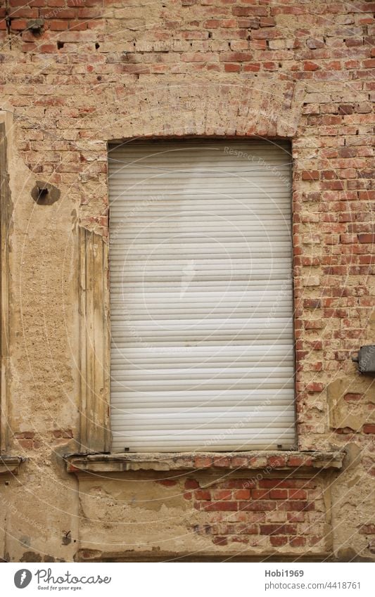 Geschlossenen Rollladen an einem Fenster in einer Fassade aus Backstein geschlossen Wand Ziegelstein Haus Bauwerk alt Altbau Architektur abgeschlossen