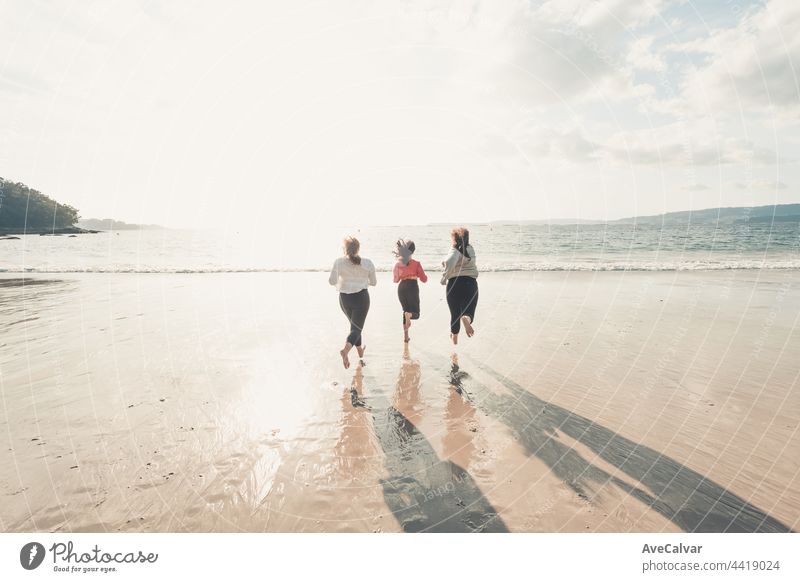 Glückliche Frauen Freunde läuft am Meer Strand während eines hellen Tages, Freunde glücklich entspannen, Spaß zu spielen am Strand in der Nähe von Meer, wenn Sonnenuntergang am Abend.