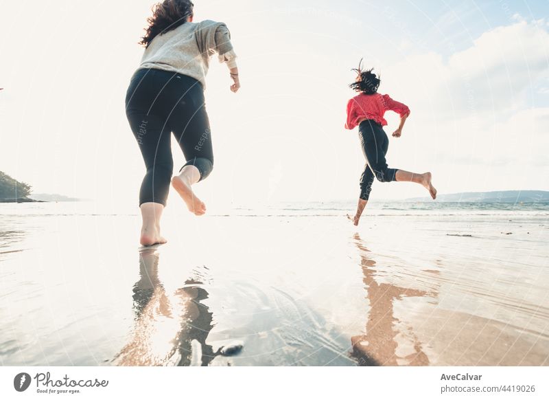 Glückliche Frauen Freunde läuft am Meer Strand während eines hellen Tages, Freunde glücklich entspannen, Spaß zu spielen am Strand in der Nähe von Meer, wenn Sonnenuntergang am Abend.