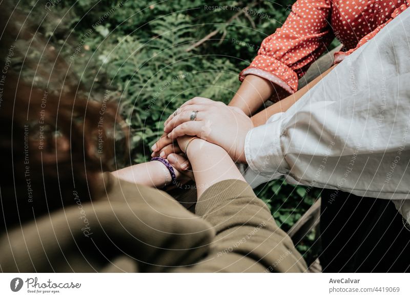 Eine Gruppe von Freunden, die sich an den Händen halten, mit den Begriffen Freundschaft, Unterstützung, Fürsorge und Zuneigung, multikulturell Händchenhalten