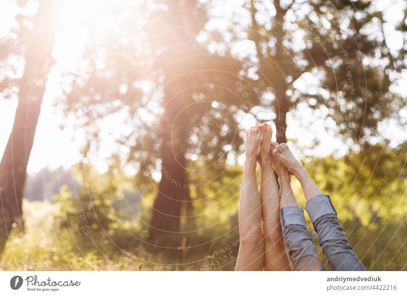 Verliebtes Paar, das im Gras liegt und die Beine hochlegt. sonniger Sommertag Fuß jung Typ menschlich zwei Liebe Fröhlichkeit Mann Glück Tag Frühling Frau