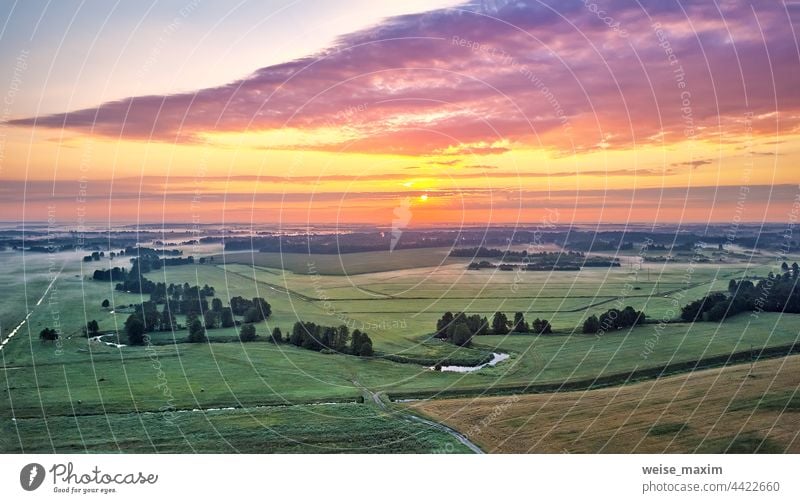 Dramatischer Sommer-Sonnenaufgang. Panorama neblige Landschaft. Nebliger Morgen am Fluss Luftaufnahme. Grüne Felder und Wiesen Natur Himmel Sonnenlicht