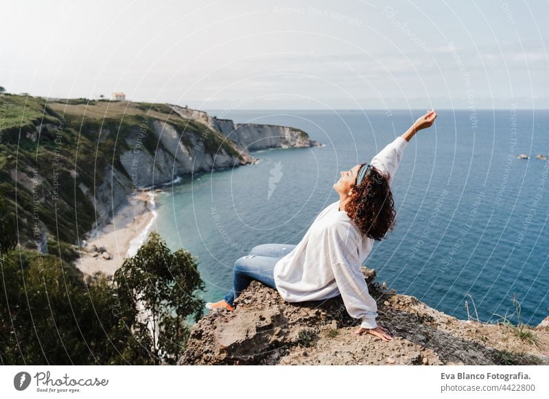 junge entspannte Frau sitzt auf der Spitze der Klippe mit Blick auf das Meer Landschaft in Asturien. Entspannen und Natur Konzept Kaukasier entspannend Klippen