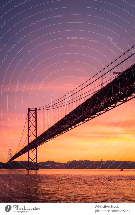 Moderne Brücke über den Fluss bei Sonnenuntergang Ufer Himmel wolkig Abend modern verbinden Denkmal Lissabon Portugal Almada 25 de abril brücke