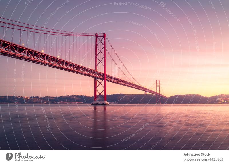 Moderne Brücke über den Fluss bei Sonnenuntergang Ufer Himmel wolkig Abend modern verbinden Denkmal Lissabon Portugal Almada 25 de abril brücke