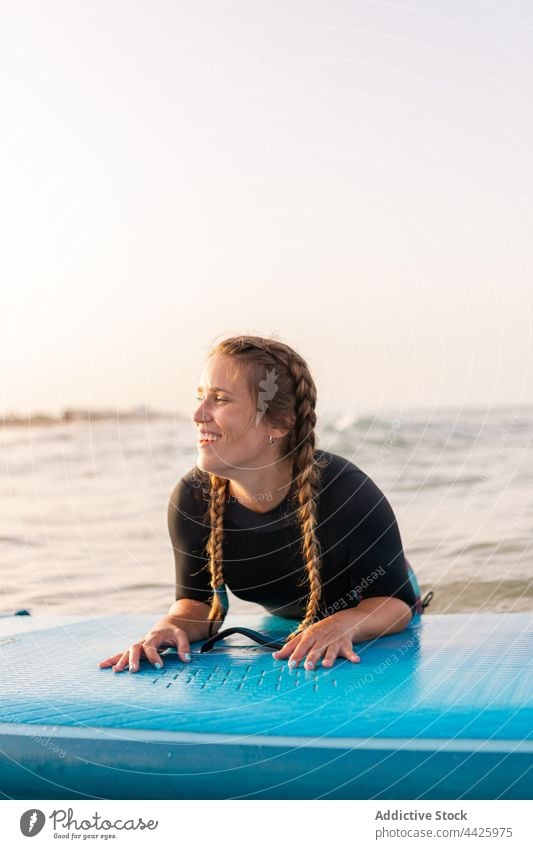 Fröhliche Frau schwimmt auf einem Paddleboard im Meer Surfer Paddelbrett Zusatzplatine SUP MEER Schwimmer schwimmen Surfbrett Sommer Holzplatte Wasser Lügen