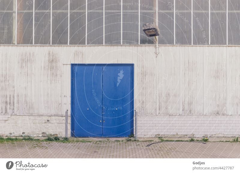 Fassade einer Fabrikhalle mit blauem Tor und Beleuchtung Lampe Architektur Fenster Gebäude Haus Wand Himmel Licht Außenaufnahme Menschenleer Mauer Bauwerk Tag