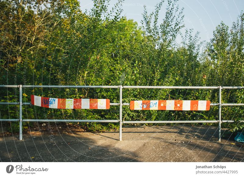 Sackgasse Straßenende Zaun Absperrung vor Natur Fußweg rot Weiß Geländer Schluss Ende Büsche Bäume Umwelt Stopp Außenaufnahme Sicherheit Barriere rot-weiß