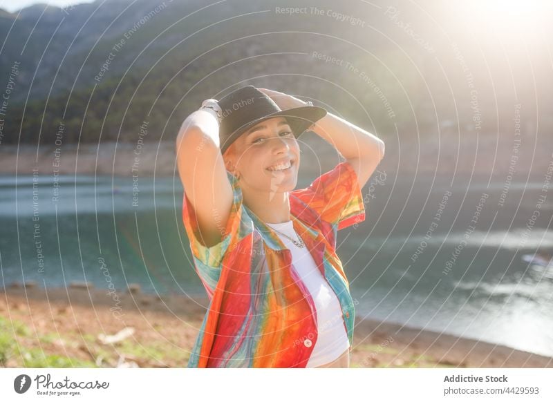 Seitenansicht Frau in einem See mit Blick auf eine Kamera Tourist cool Stil Natur Ufer Baum Reflexion & Spiegelung Urlaub Hut Reisender lässig Bekleidung