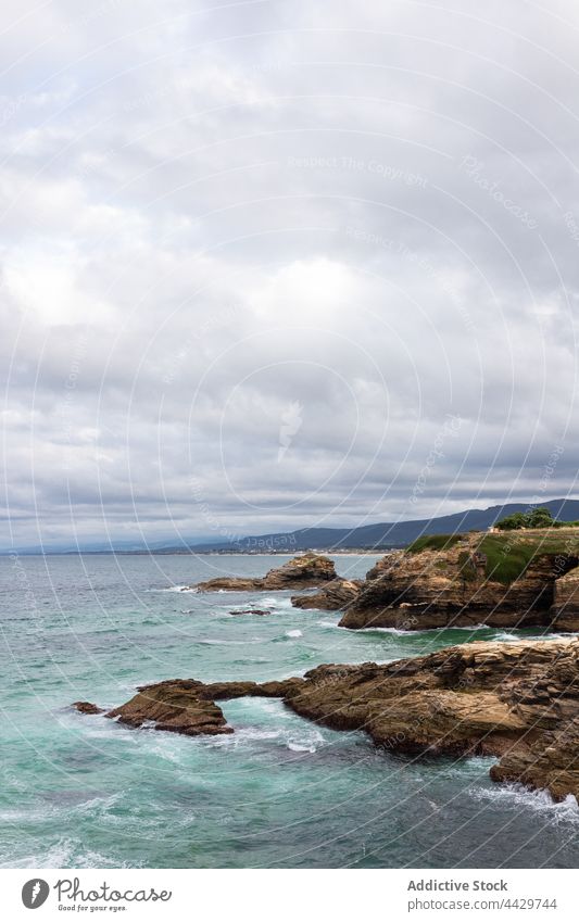 Meer und raue Berge unter bewölktem Himmel Reittier wolkig Natur Landschaft Hochland Air stürmisch wellig schaumig Küste Berge u. Gebirge Atmosphäre MEER