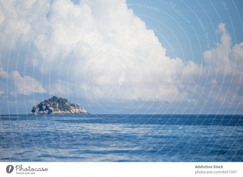 Plätscherndes Meer mit felsigem Hügel am Horizont MEER blau Natur Umwelt Wasser Insel Rippeln Meereslandschaft malerisch Felsen Blauer Himmel Stein wolkig