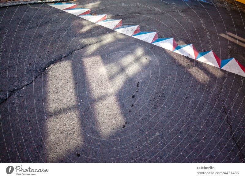 Kuriose Straßenmarkierung mit Lichtflecken dunkel gasse sommer stadt stadtkern torun tourismus touristik fahrbahnmarkierung straße radweg abbiegen asphalt