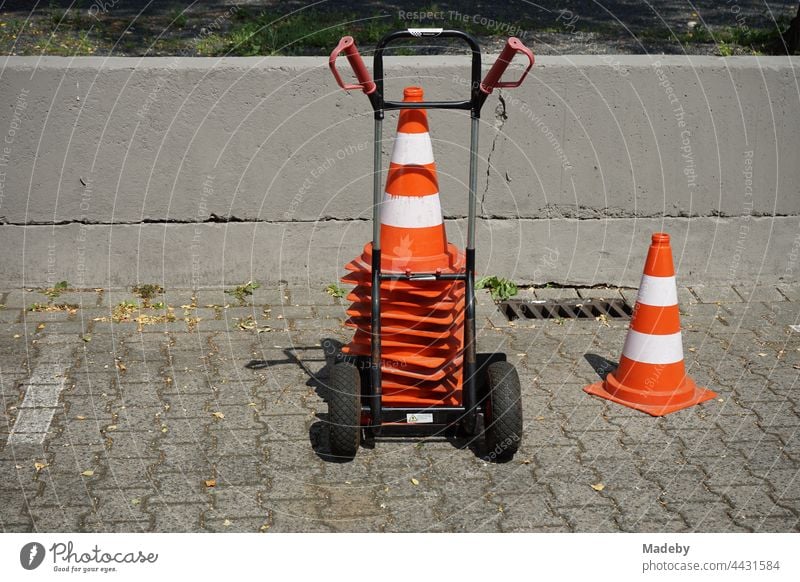 Gestapelte Lübecker Hütchen auf einer Sackkarre auf dem grauen Verbundpflaster des Parkplatz in der Klassikstadt im Sommer bei Sonnenschein im Stadtteil Fechenheim in Frankfurt am Main in Hessen