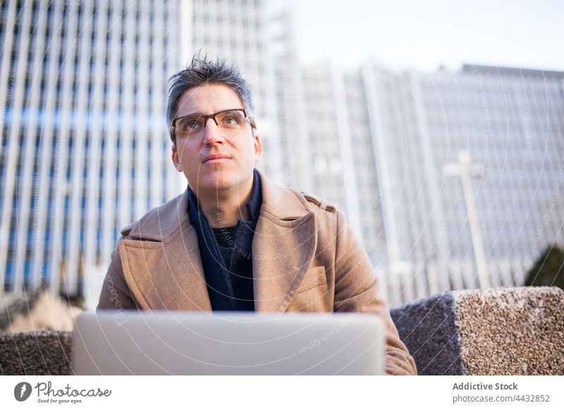 Mann mit Laptop auf der Straße Großstadt männlich benutzend freiberuflich Gerät Apparatur urban Arbeit Browsen ernst Internet Netbook Computer modern Surfen