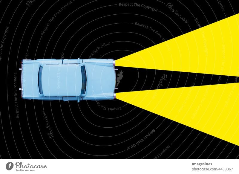 Hellblaues Retro Spielzeugauto und Xenonlampen-Scheinwerferkonzept auf schwarzem Hintergrund. Mieten Sie ein Auto, Reiseunfall. minimales Konzept abstrakt