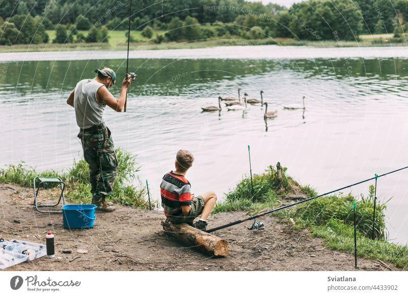 Ein junger Mann bringt seinen Kindern während eines Familienurlaubs auf einem Campingplatz das Angeln bei. Hobbys, Urlaub, Wochenenden, Angeln Fischen