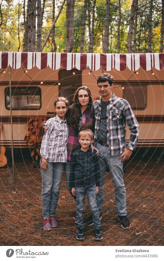 Glückliche Familie auf einem Campingausflug zur Entspannung im Herbstwald. Wohnmobil-Anhänger. Herbstsaison Ausflug ins Freie fallen Natur Vater Mutter