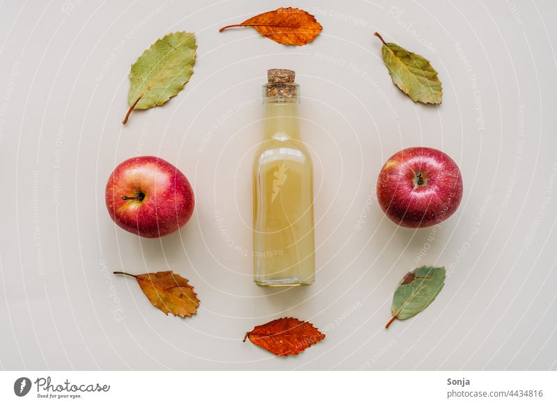 Naturtrüber Apfelsaft in einer Glasflasche und Herbstblätter Apelsaft frisch umrahmt Design Draufsicht Getränk Saft Gesunde Ernährung Diät