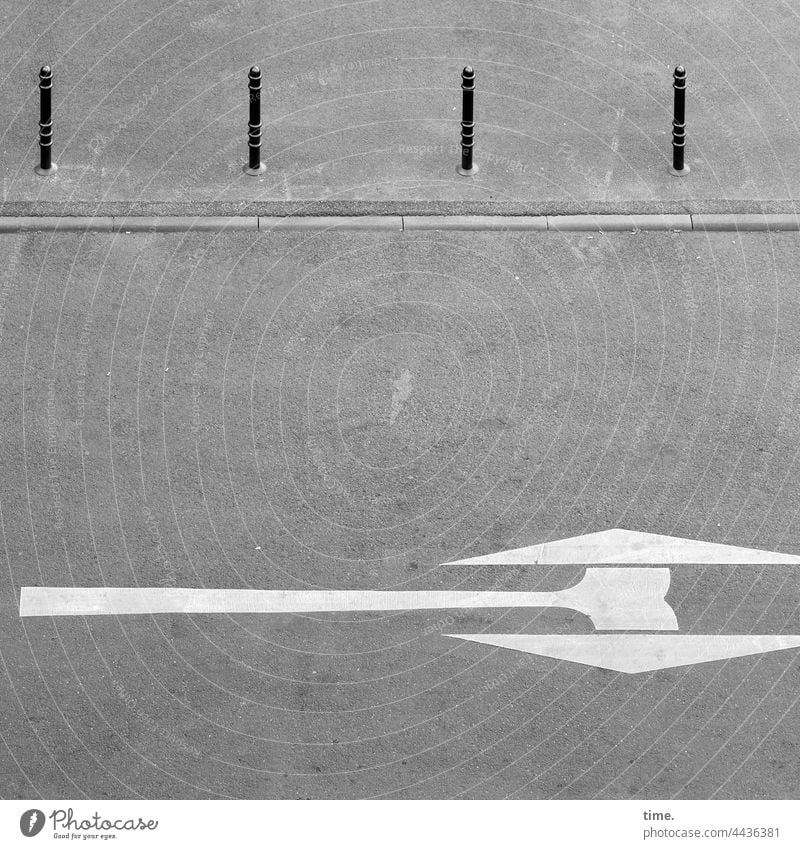 Doppelaxt mit vier Zuschauern straße pfeile straßenverkehr richtungsanzeiger poller bordstein asphalt bordsteinkante stein beton grau urban