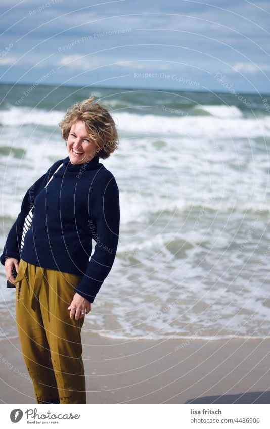 GUTE LAUNE - WAS WILL MAN MEHR - LACHENDE FRAU Farbfoto Ferien & Urlaub & Reisen Frau 30-45 Jahre Erwachsene Außenaufnahme Meer Wellen gutes Wetter Herbst Sylt