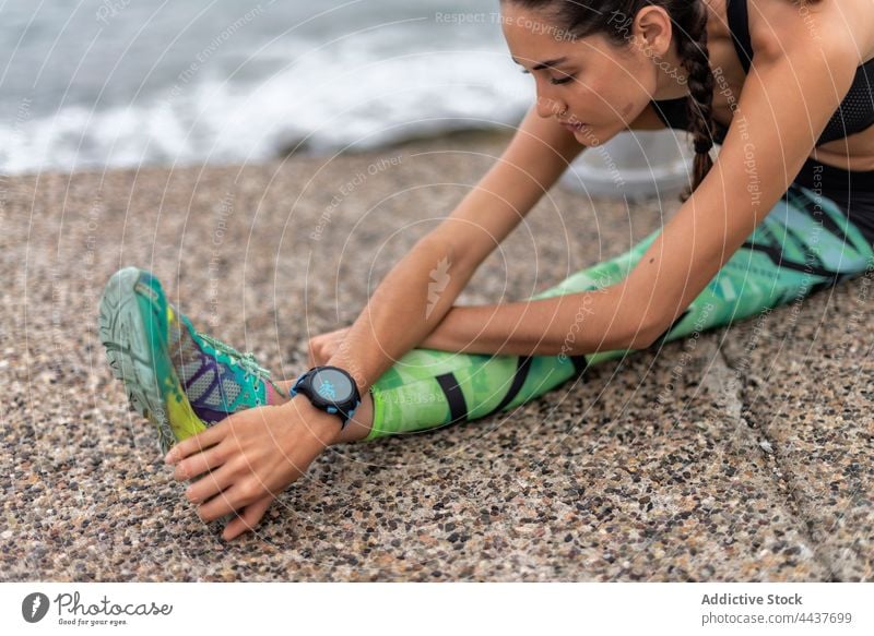 Flexible Sportlerin streckt die Beine beim Training Ausfallschritt Übung Dehnung Athlet Stauanlage beweglich Aufwärmen Frau Seitenlonge üben Fitness Vitalität