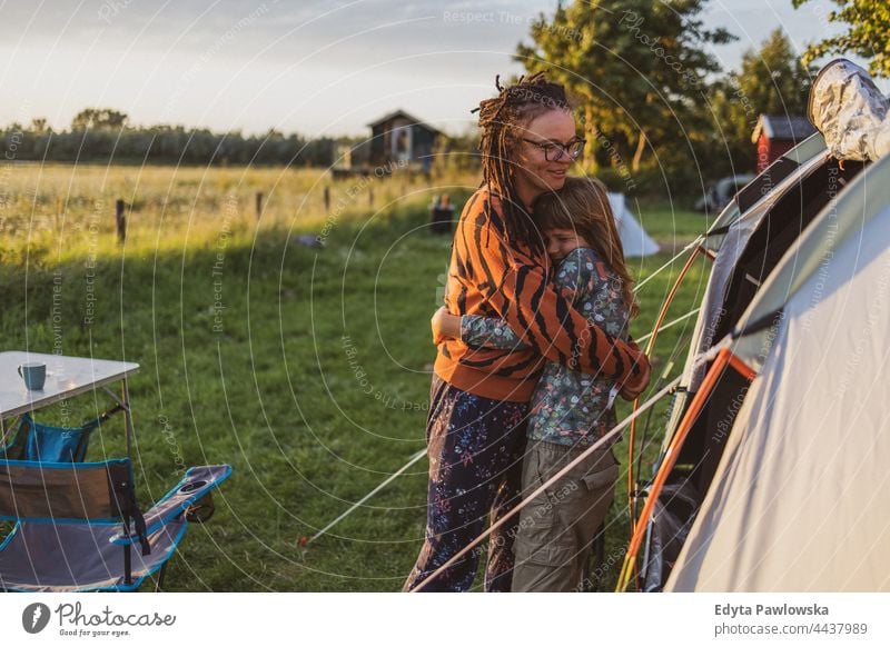 Mutter und Tochter umarmen sich vor dem Zelt auf dem Campingplatz Eltern Zusammensein Liebe umarmend Spaß Freude Kinder Familie Fahrrad Fahrradfahren Wiese Gras