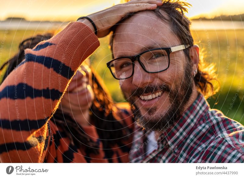 Porträt eines Paares, das sich bei Sonnenuntergang im Freien amüsiert echte Menschen authentisch Spaß Spaß haben Natur Liebe Zusammensein Gesicht Frau Mann