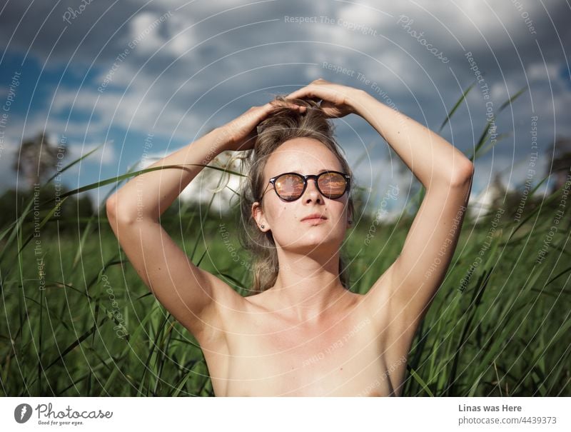 Der heiße Sommer der sexy Girls neigt sich dem Ende zu. Oben-ohne-Blondinen genießen jedoch noch das warme Wetter, die grüne Natur und einige dunkelblaue Wolken. Sonnenbrillen sind alles, was sie brauchen, keine Kleidung, was auch immer.