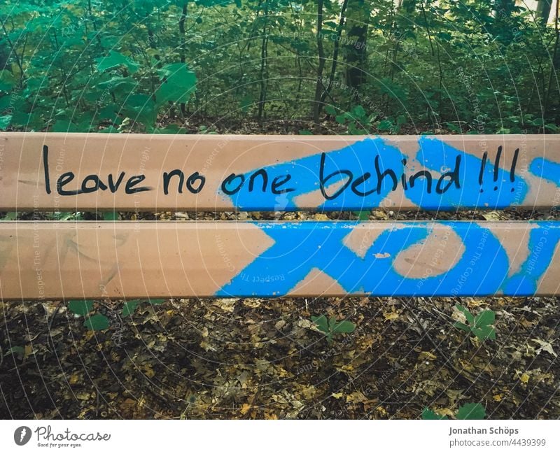 Leave no one behind!!!, lass niemanden zurück als Schrift auf einer Bank Wörter Wort Aussage Aufforderung auffordern Typografie Typographie Buchstaben