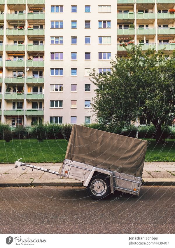 Auto Anhänger freistehend auf Straße vor Wohnblock Autoanhänger Logistik Umzug Lagerung transport Transport Güterverkehr & Logistik Lastwagen Verkehr Fahrzeug