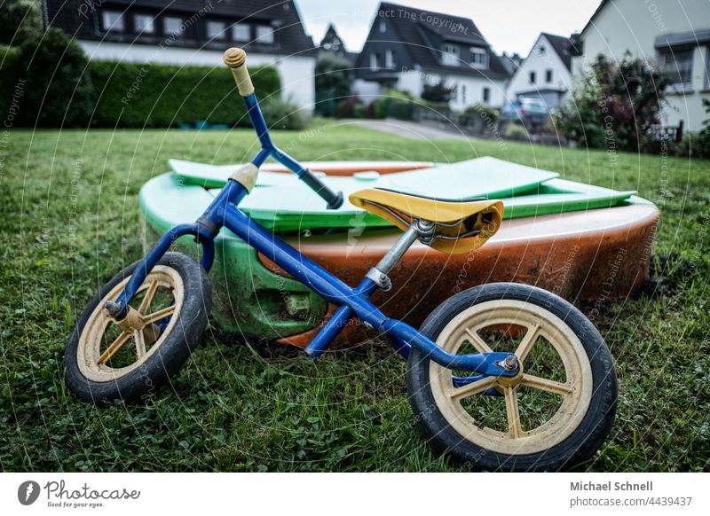 Altes Rad, abgelegtan einem Sandkasten für Kleinkinder Laufrad Kind Kindheit Außenaufnahme Bewegung Fahrrad Spielen verflossen vergangen überblicken Sehnsucht