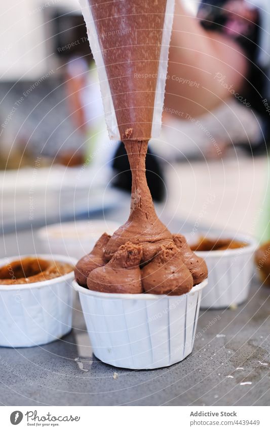 Schokoladencreme auf Muffins gießen Bäcker Dessert Sahne lecker geschmackvoll süß Backwarenbeutel Cupcake Lebensmittel Küchenchef Koch Leckerbissen