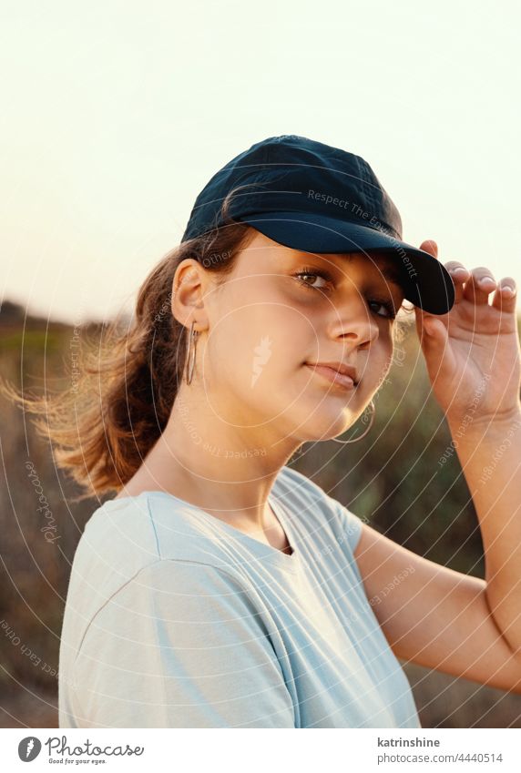 Teenager-Mädchen mit dunkelblauer Baseballmütze und T-Shirt im Freien Jugendlicher Landschaft abgelegt Kaukasier Attrappe visier tragend T-Shirts Kindheit Frau