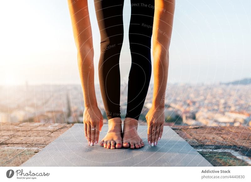 Crop-Frau beim Stehenden Vorwärtsbeugen in der Stadt Yoga Dehnung beweglich Gesunder Lebensstil Wohlbefinden Vitalität Energie Großstadt Unterlage Pose