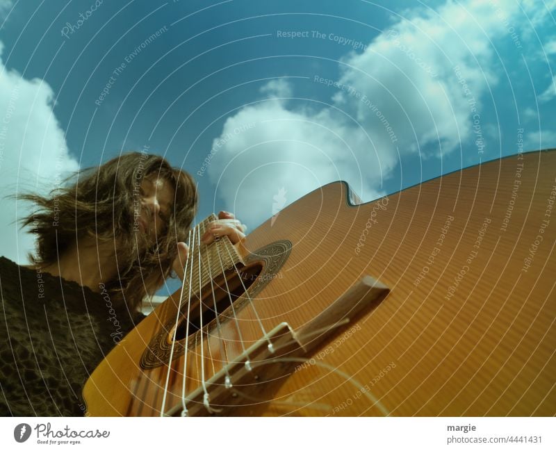 Gitarrenspielerin unter blauen Himmel mit Wolken Musikinstrument Saiteninstrumente Freizeit & Hobby musizieren Gitarrensaite Detailaufnahme Nahaufnahme Musiker